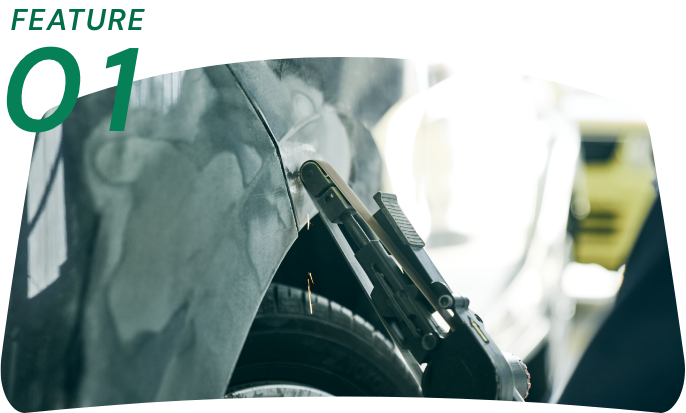 FEATURE 01: 車のフェンダー部分を修理するための工具を使用している様子