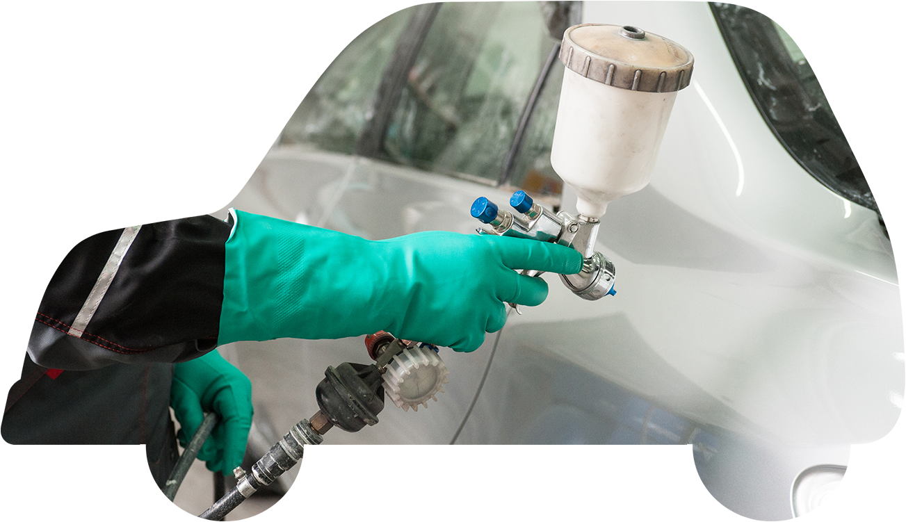 緑色の手袋をつけた作業員がスプレーガンを使用して車のボディを塗装している